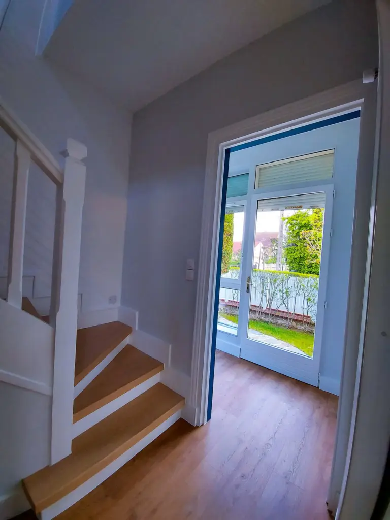 Escalier après rénovation : repeint en blanc, marches habillées de bois clair